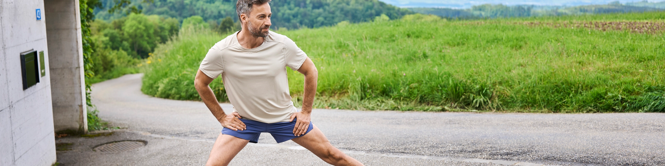 Mann beim Aufwärmen vor dem Sport – Symbol für Gesundheit und Sicherheit durch die Einkommensabsicherung.