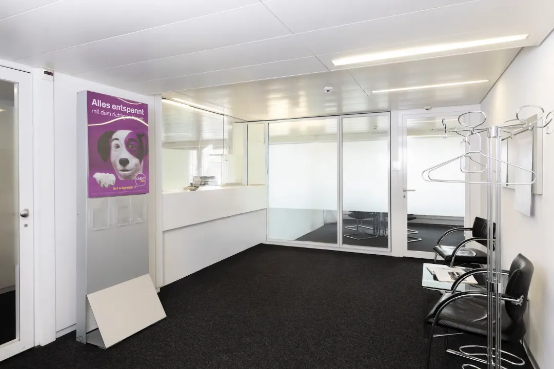 Schalterbereich der BANK-now Filiale Olten mit Empfangstheke, Sitzgelegenheiten und heller Raumgestaltung.