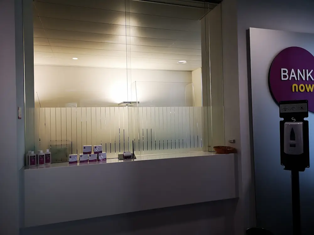 Empfangsbereich der BANK-now Filiale in Fribourg mit Willkommensbanner