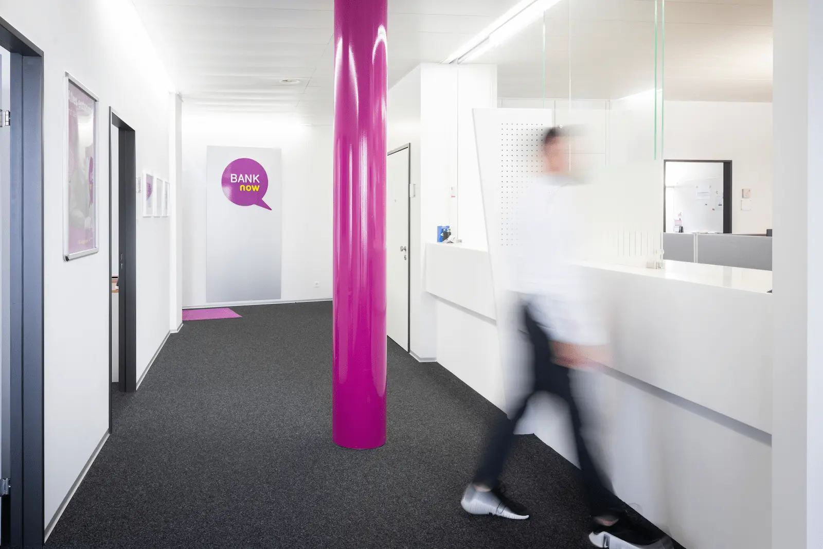 Eingangsbereich der BANK-now Filiale Zürich mit pinker Säule und Blick zum Empfang.